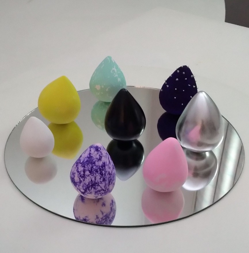 Conjunto de piezas de cerámica de colores sobre una superficie espejada